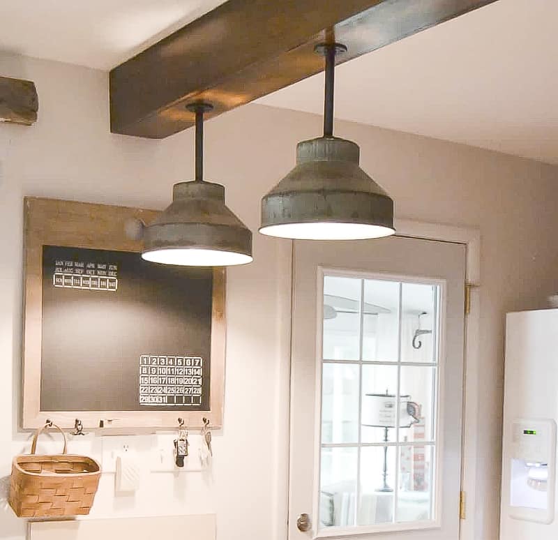 Looking to update the lighting in your kitchen? These DIY Light Fixtures upcycle farm pieces to create custom farmhouse lighting in this kitchen.