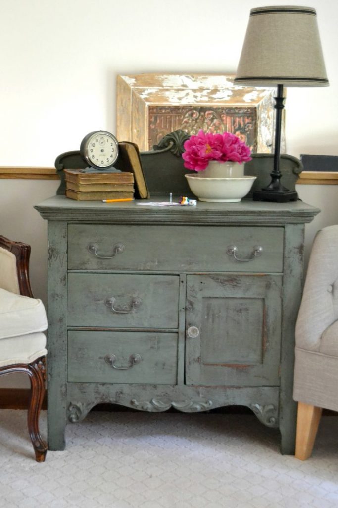 Even a wooden chest of drawers left in a garage for a long time deserves a makeover. Click over to see how I transformed this wooden chest of drawers with a technique of stain over paint. 