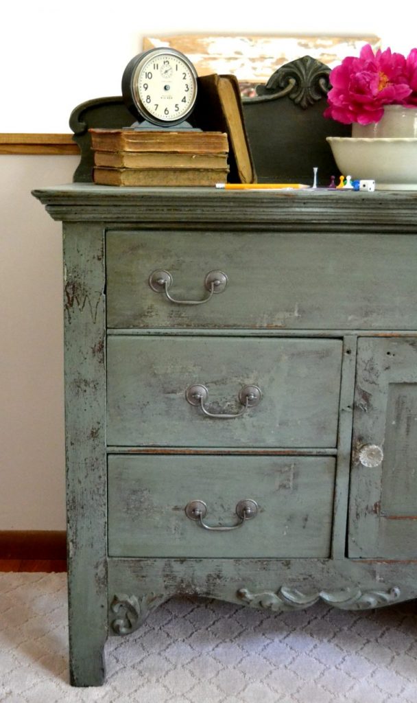 Even a wooden chest of drawers left in a garage for a long time deserves a makeover. Click over to see how I transformed this wooden chest of drawers with a technique of stain over paint. 