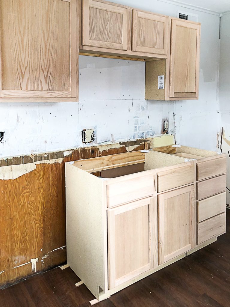 If you are thinking about adding unfinished wood cabinets to your home or a flip house, click over to see how we added them to our third project and what a difference they made to the kitchen.