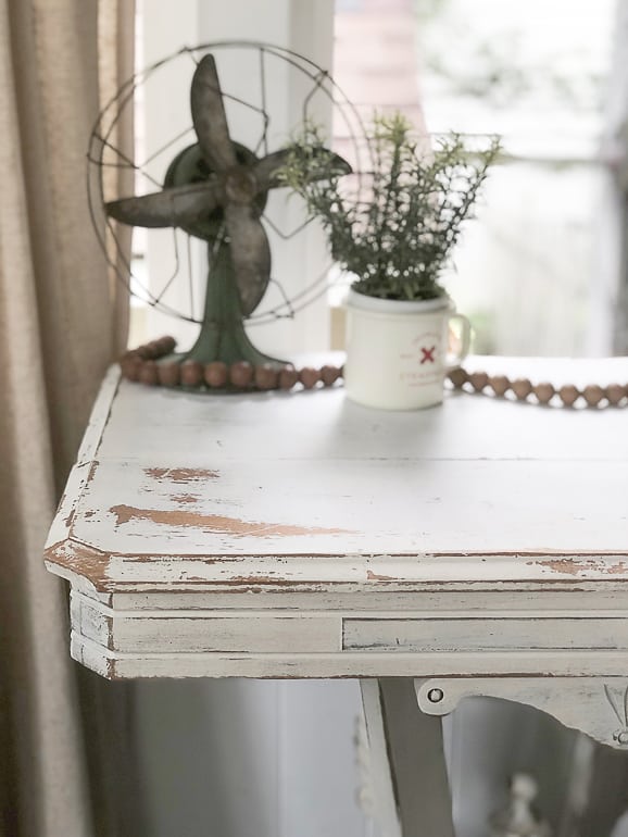 If you like the look of painted antique furniture, but want to save money to have it, this post will show you how to paint and distress a wood table in a few, easy steps.