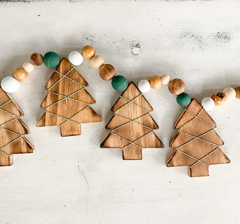 This DIY Wood Burned Christmas Tree Garland takes some common craft items and turns them into charming decor for the Christmas season.