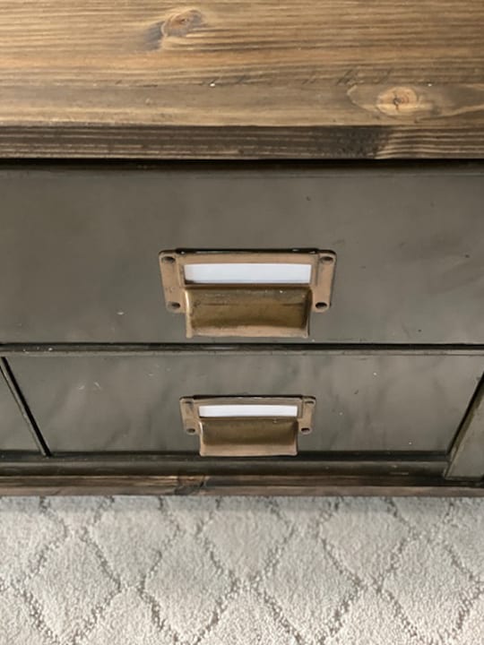 Create a DIY Industrial Coffee Table from an industrial metal drawer piece, some wood, stain and old casters to get the look you want for less!