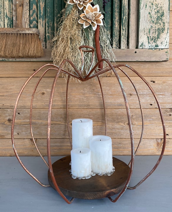 This DIY Pumpkin Lantern came together with a yard sale find, scrap wood from the garage, and some inexpensive pillar candles from Walmart.