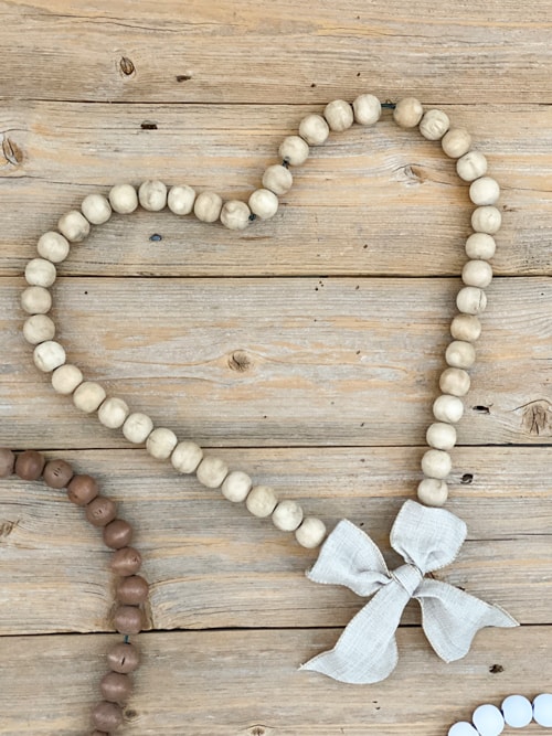 Looking for easy ways to decorate for Valentine's Day? These DIY Wood Bead Valentine Wreaths turn dollar store items into 3 pretty wreaths.