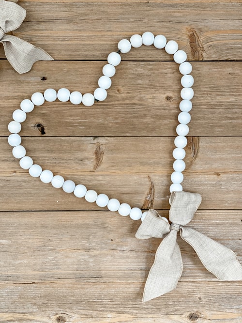 Looking for easy ways to decorate for Valentine's Day? These DIY Wood Bead Valentine Wreaths turn dollar store items into 3 pretty wreaths.