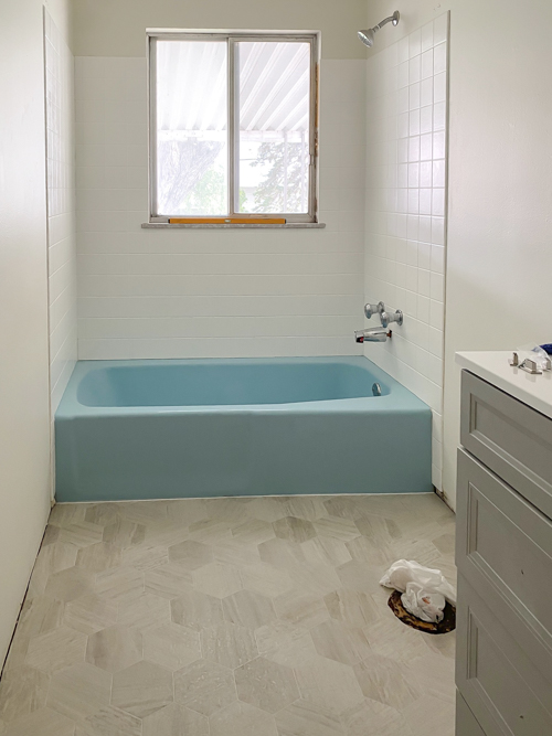 We turned a blue tub white in our flip with budget-friendly bathtub refinishing by Surface Specialists. It was fast, affordable, and a total bathroom game-changer.