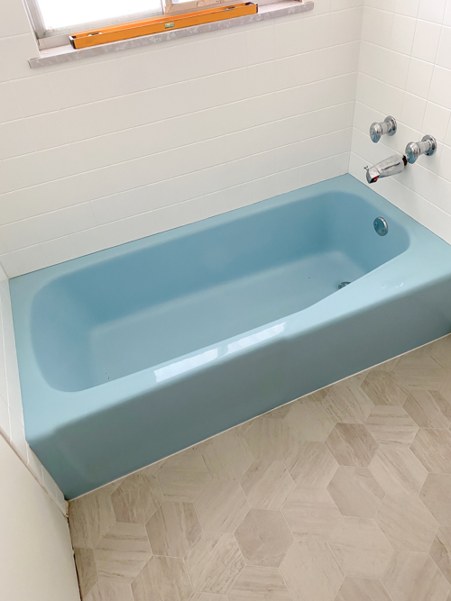 We turned a blue tub white in our flip with budget-friendly bathtub refinishing by Surface Specialists. It was fast, affordable, and a total bathroom game-changer.