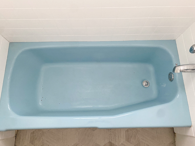 We turned a blue tub white in our flip with budget-friendly bathtub refinishing by Surface Specialists. It was fast, affordable, and a total bathroom game-changer.