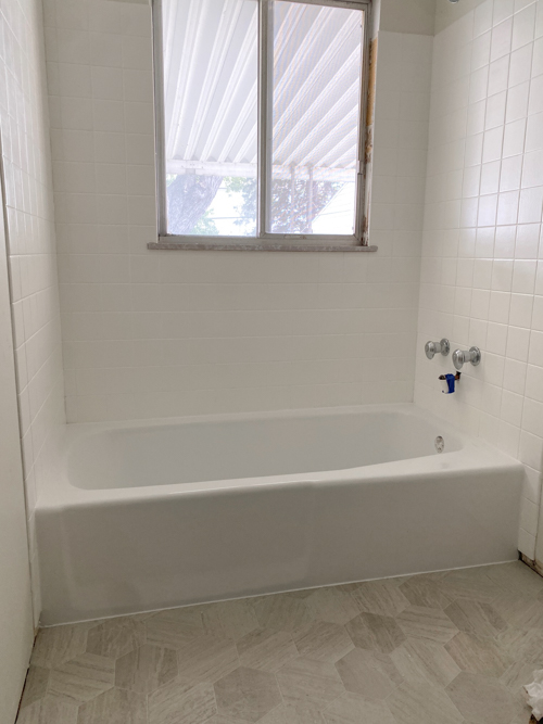 We turned a blue tub white in our flip with budget-friendly bathtub refinishing by Surface Specialists. It was fast, affordable, and a total bathroom game-changer.