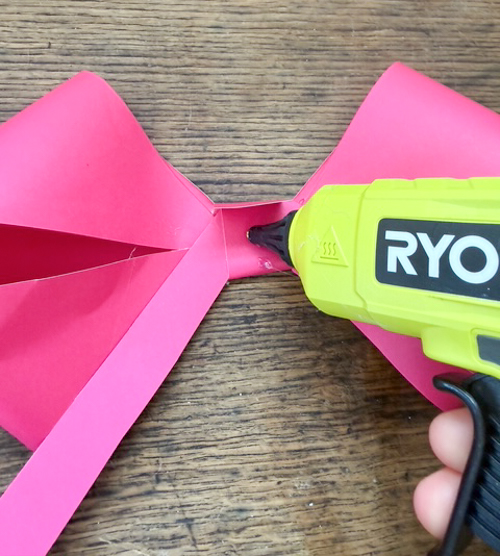 Learn how easy it is to make DIY paper bows with hot glue, paper, and scissors. Make them for birthdays, gifts, Valentine's Day decor, or turn them into garlands.
