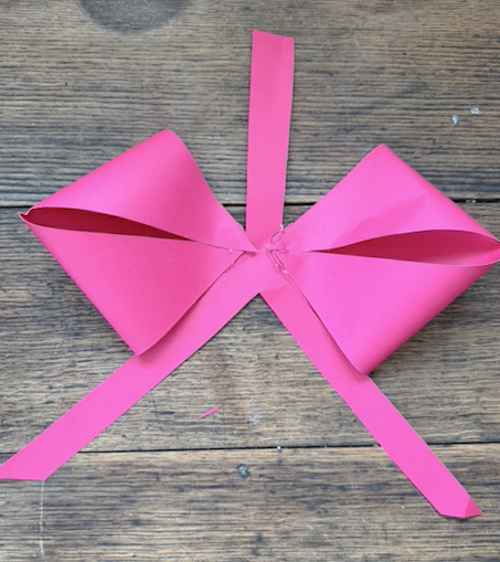 Learn how easy it is to make DIY paper bows with hot glue, paper, and scissors. Make them for birthdays, gifts, Valentine's Day decor, or turn them into garlands.