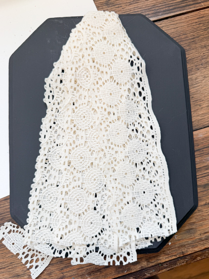 DIY Halloween Ghost Decor is easy to make with a wood plaque, lace trim, and a few simple supplies. Create this cute DIY ghost wall hanging on a budget.