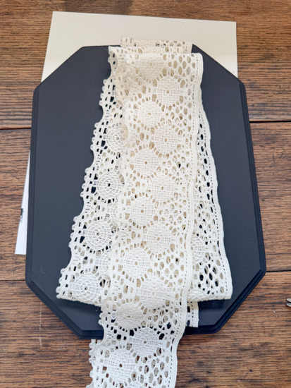 DIY Halloween Ghost Decor is easy to make with a wood plaque, lace trim, and a few simple supplies. Create this cute DIY ghost wall hanging on a budget.