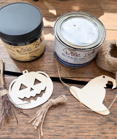 Make this DIY Rustic Halloween Garland with Dollar Tree wood cutouts, stain, witch hats, velvet ribbon, twine, and mini witch brooms.